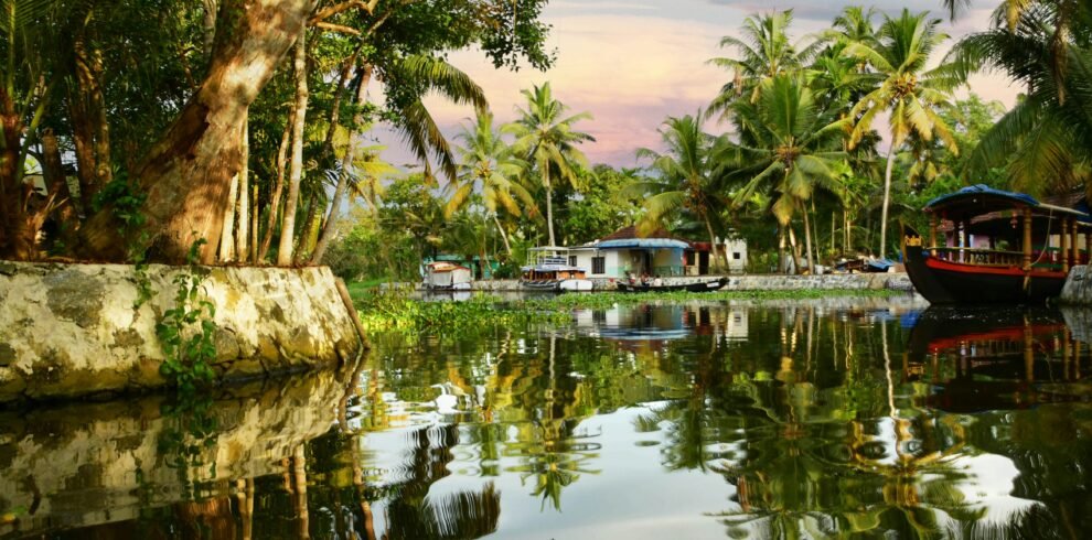 Kerala 5 day tour — traditional houseboat cruising through Alleppey backwater canals at golden hour with coconut palms