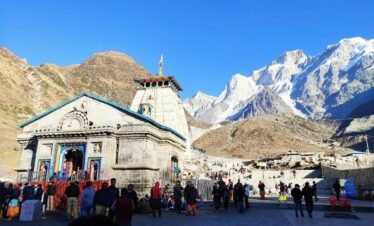Chardham Yatra helicopter flying over Kedarnath temple with snow-covered Himalayan peaks in background