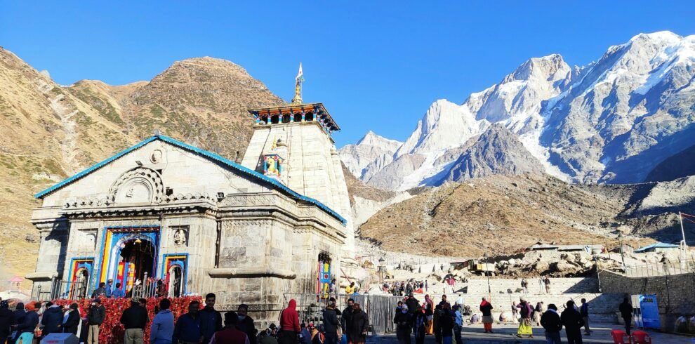 Chardham Yatra helicopter flying over Kedarnath temple with snow-covered Himalayan peaks in background