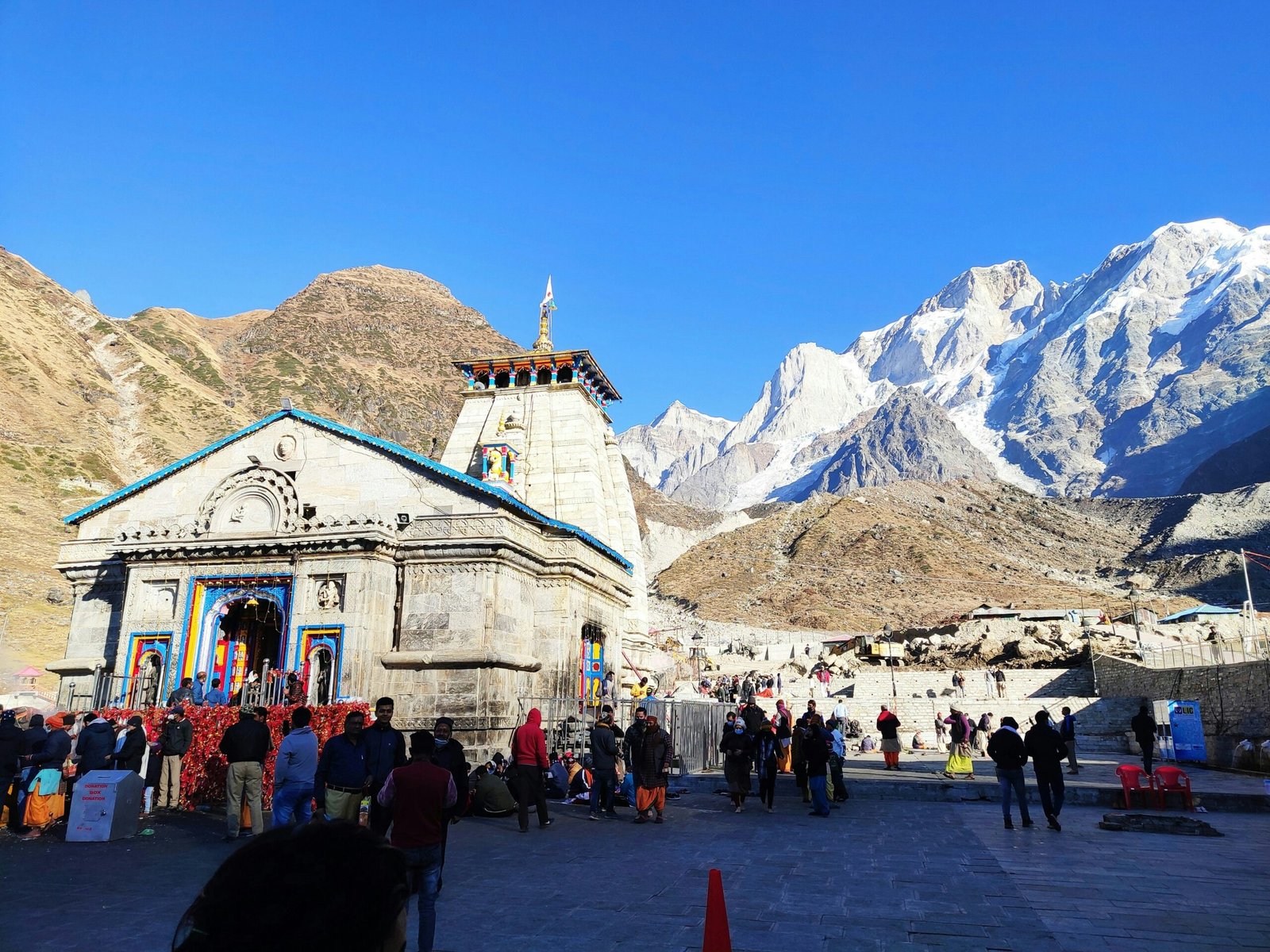 Chardham Yatra helicopter flying over Kedarnath temple with snow-covered Himalayan peaks in background