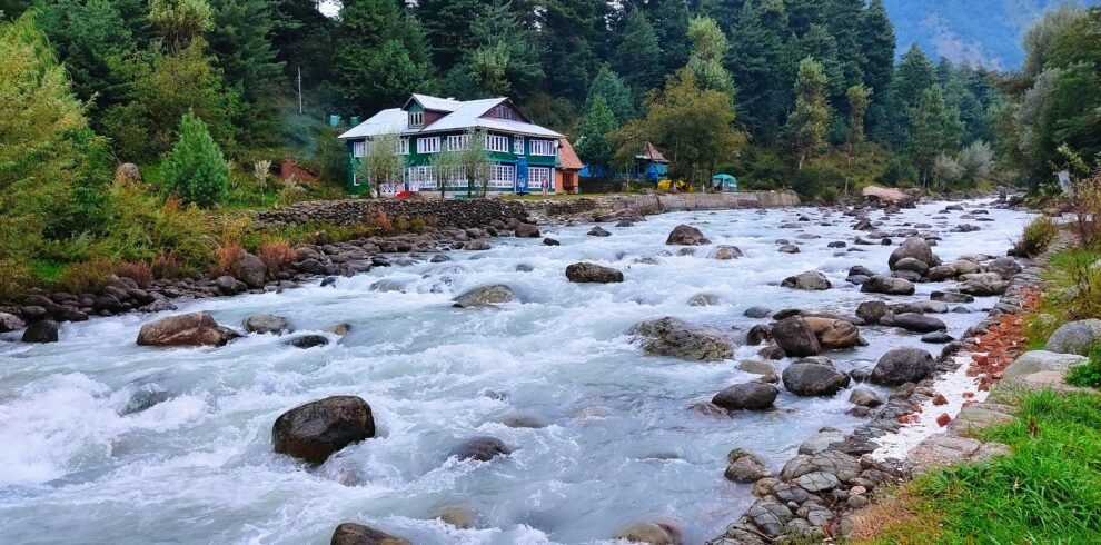 Kashmir tour package – houseboat on Dal Lake with snow-capped Himalayas at sunrise