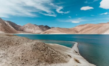 Leh Ladakh tour panoramic view of Pangong Lake with blue water and snow-capped Himalayan mountains