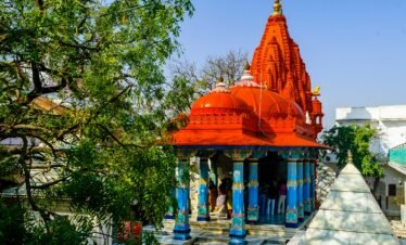 Rajasthan religious tour — Khatu Shyam Ji temple decorated facade with devotees offering flowers Sikar district