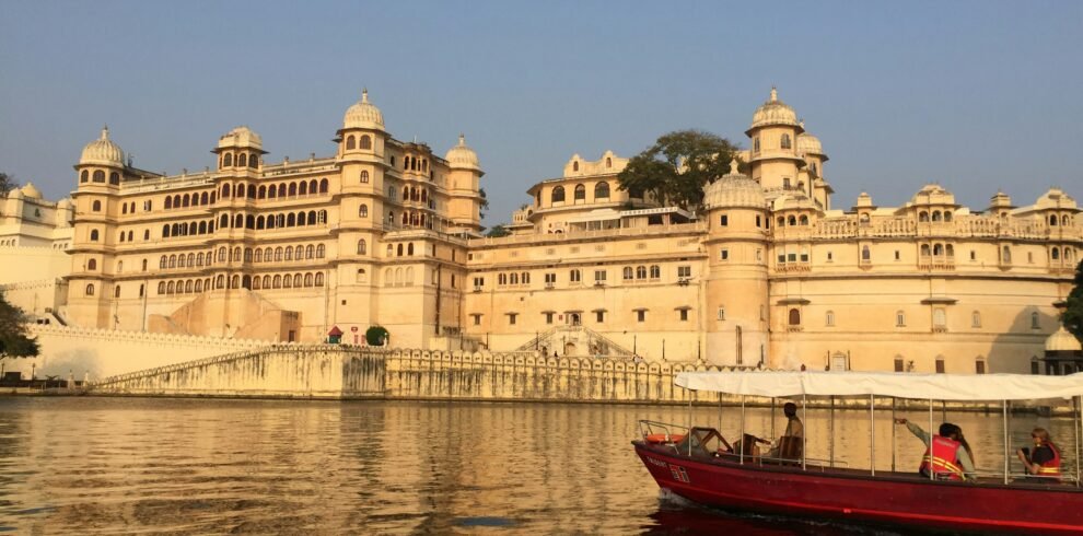 Udaipur Mount Abu tour — City Palace Udaipur illuminated at night with reflection on Lake Pichola