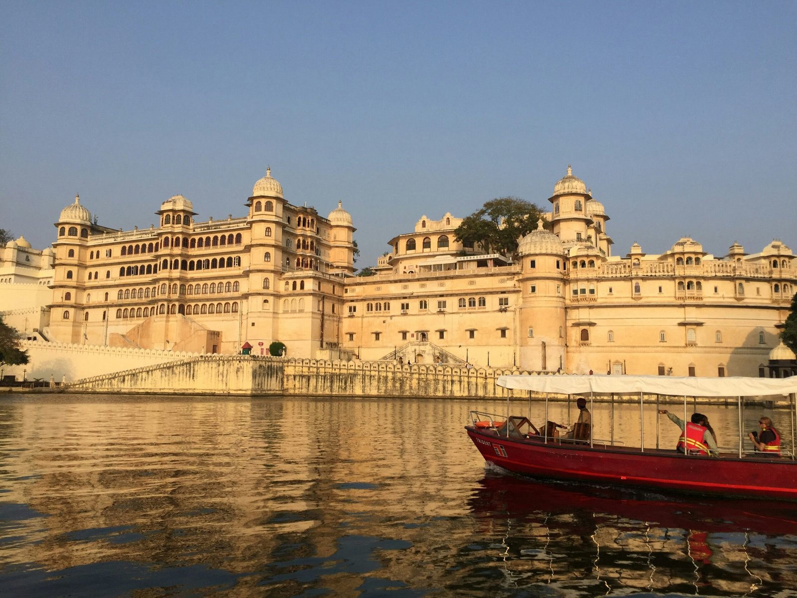 Udaipur Mount Abu tour — City Palace Udaipur illuminated at night with reflection on Lake Pichola