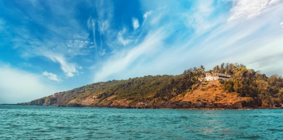 Budget Goa package — Baga Beach North Goa golden shore palm trees tourists and beach shacks aerial view