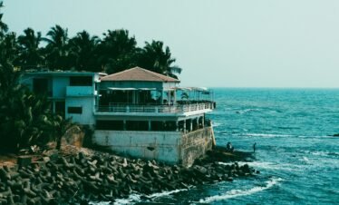 Goa honeymoon package — couple walking on Baga Beach at sunset with golden Arabian Sea waves Goa India