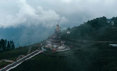 Sikkim Pelling Darjeeling tour — Pelling skywalk glass bridge over clouds with Kanchenjunga range behind